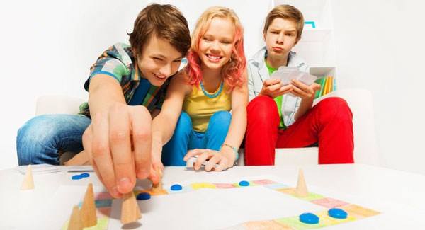 Teens playing a board game.