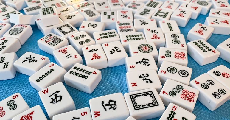 Mahjong tiles scattered on blue background.