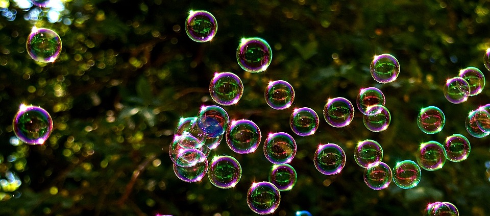 lots of iridescent bubbles on a black background
