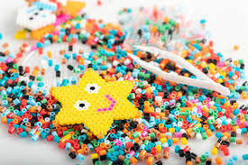 Star craft of perler beads on top of a pile of beads.