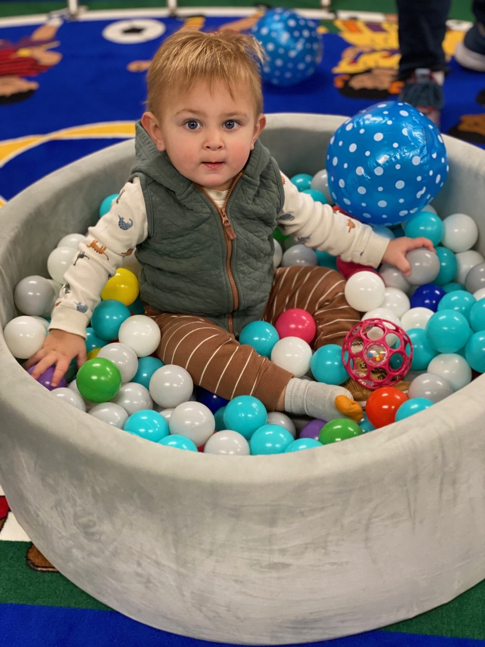 Child playing in multi colored ball pit during Tiny Tales 