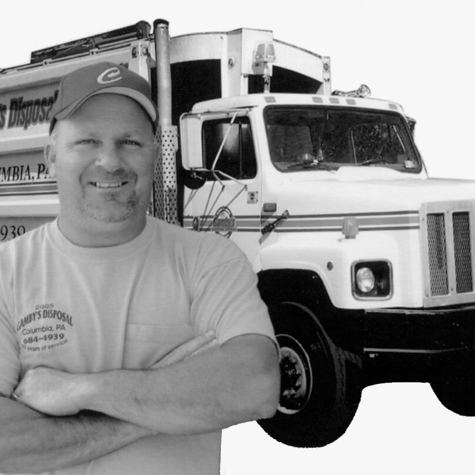 Black and white photo of man standing in front of a garbage truck