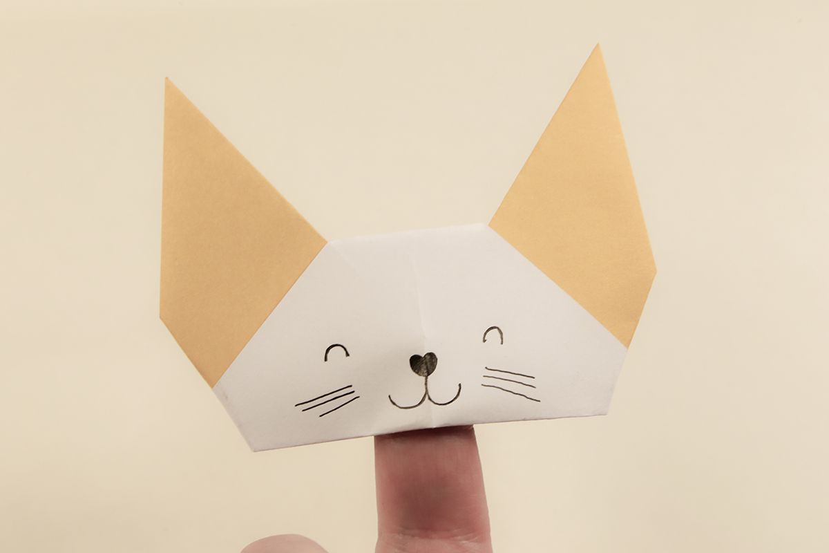 Origami cat head on finger.