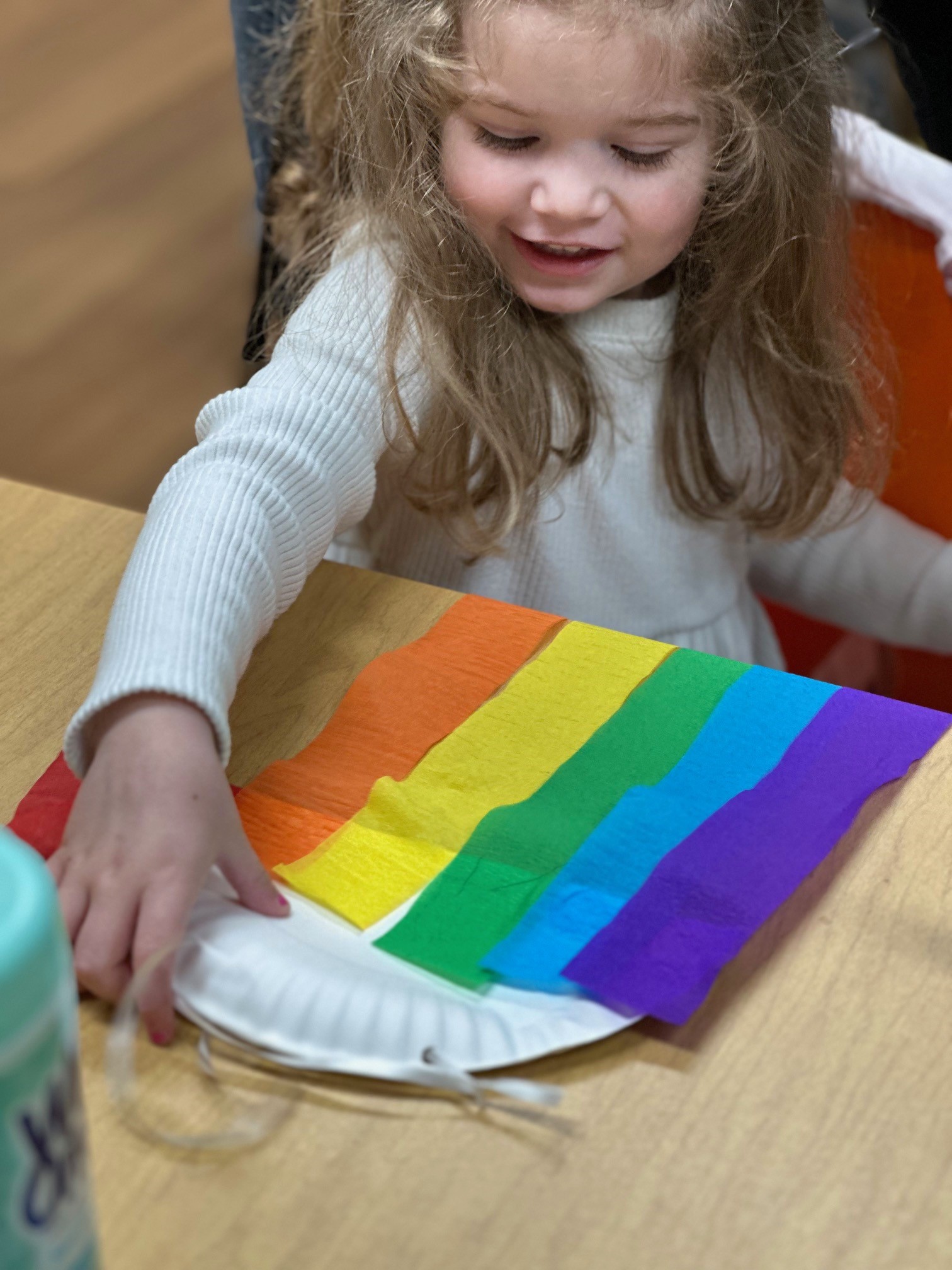 Child making rainbow craft during story time