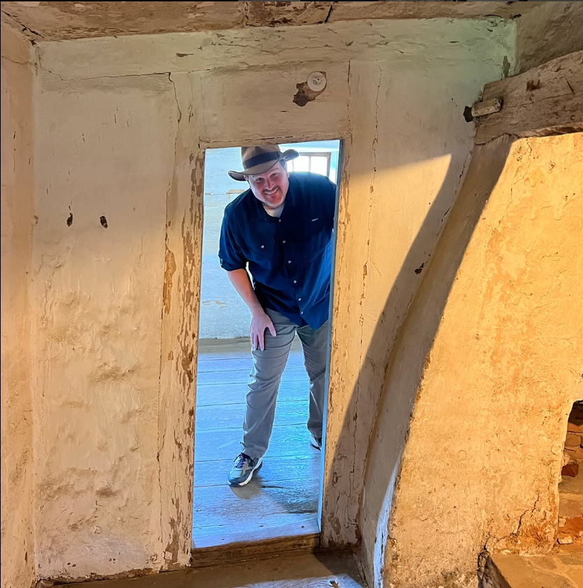 Man with adventurer's hat looking through doorway