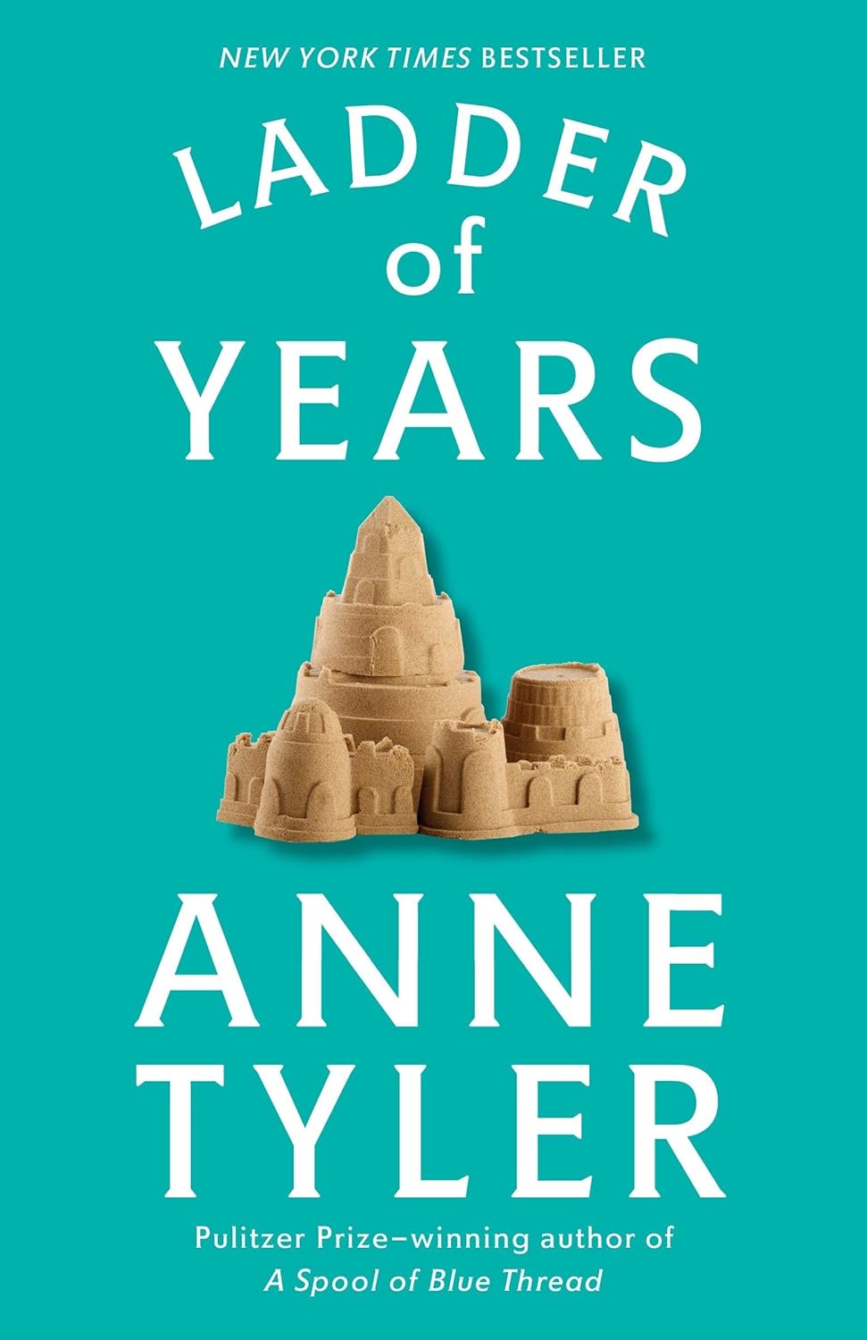 Cover of ladder of tears is teal with white font featuring a brown sand castle in the center.