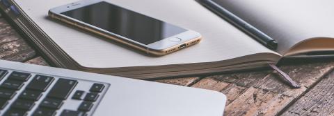 Image of cell phone, laptop and notebook