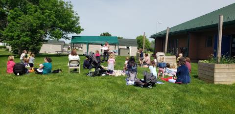 Families sitting on grass outside building