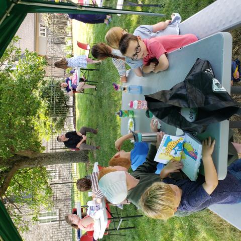 Families sitting at tables outside