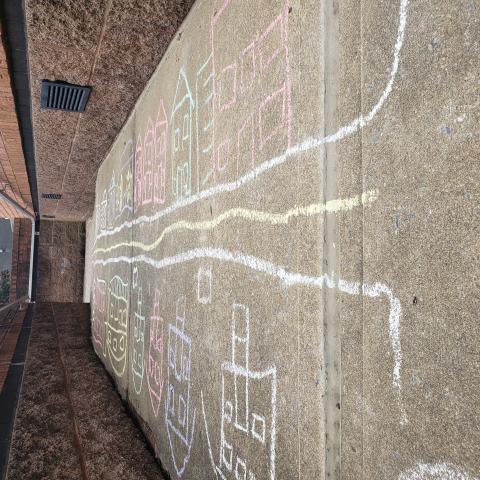 houses along a street drawn on a sidewalk with chalk of different colors