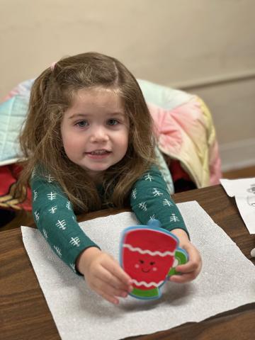 Child showing craft made during story time 