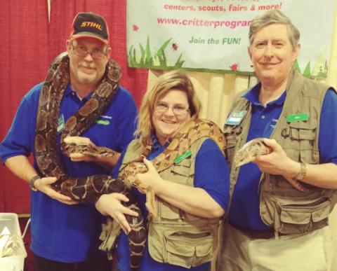 Critter Connection staff holding reptiles.