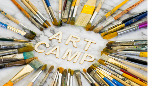 "Art Camp" surrounded by paint brushes, etc.