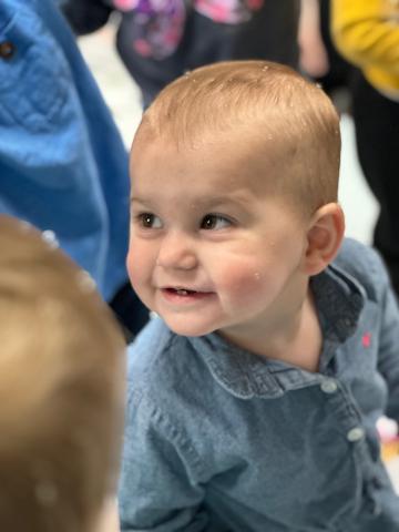 Child wearing blue shirt playing during story time
