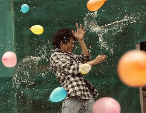 Boy being pelted with water balloons.