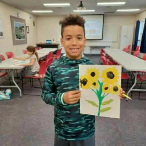 boy with picture he made of flowers