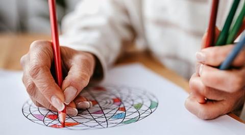 photo of adult coloring with colored pencils