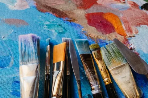 Paintbrushes on painted background.