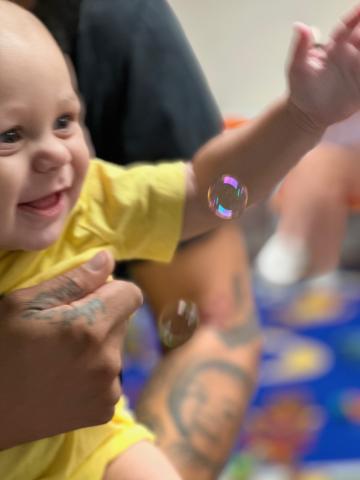 Baby smiling at bubbles