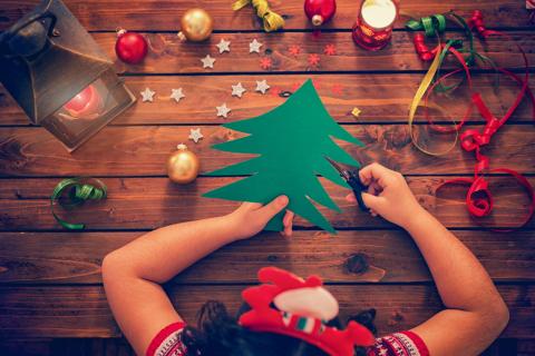 Child cutting out Christmas Tree.