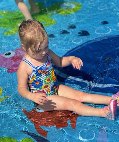 Child playing in blue splash pad