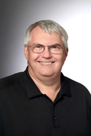 Photo of male wearing black shirt and glasses