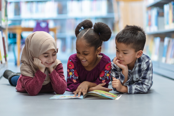 Three children reading a book