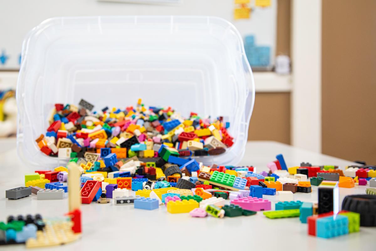 Colorful plastic blocks spilling from clear plastic bin.