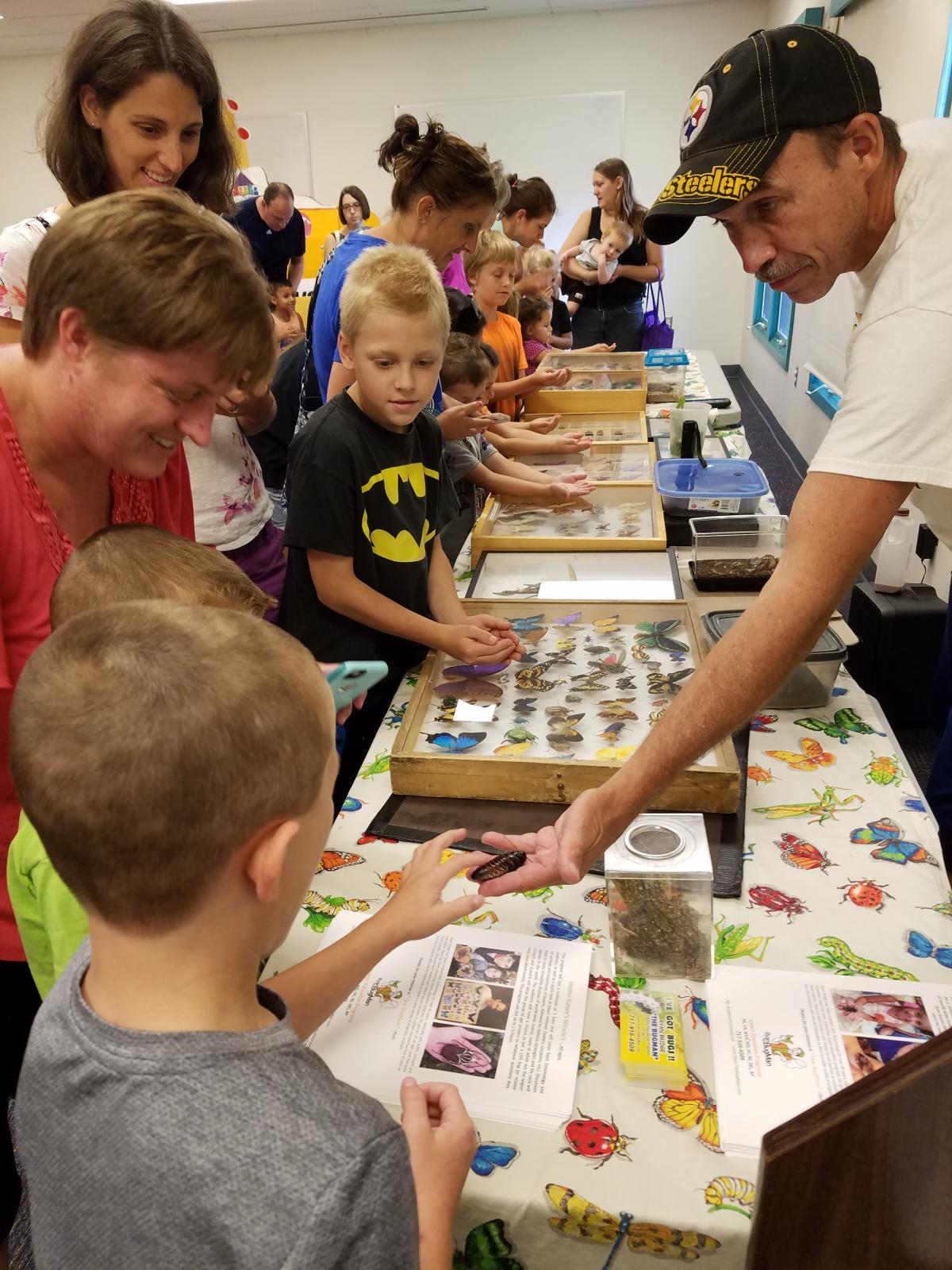 tables of insects in cases, people looking at them