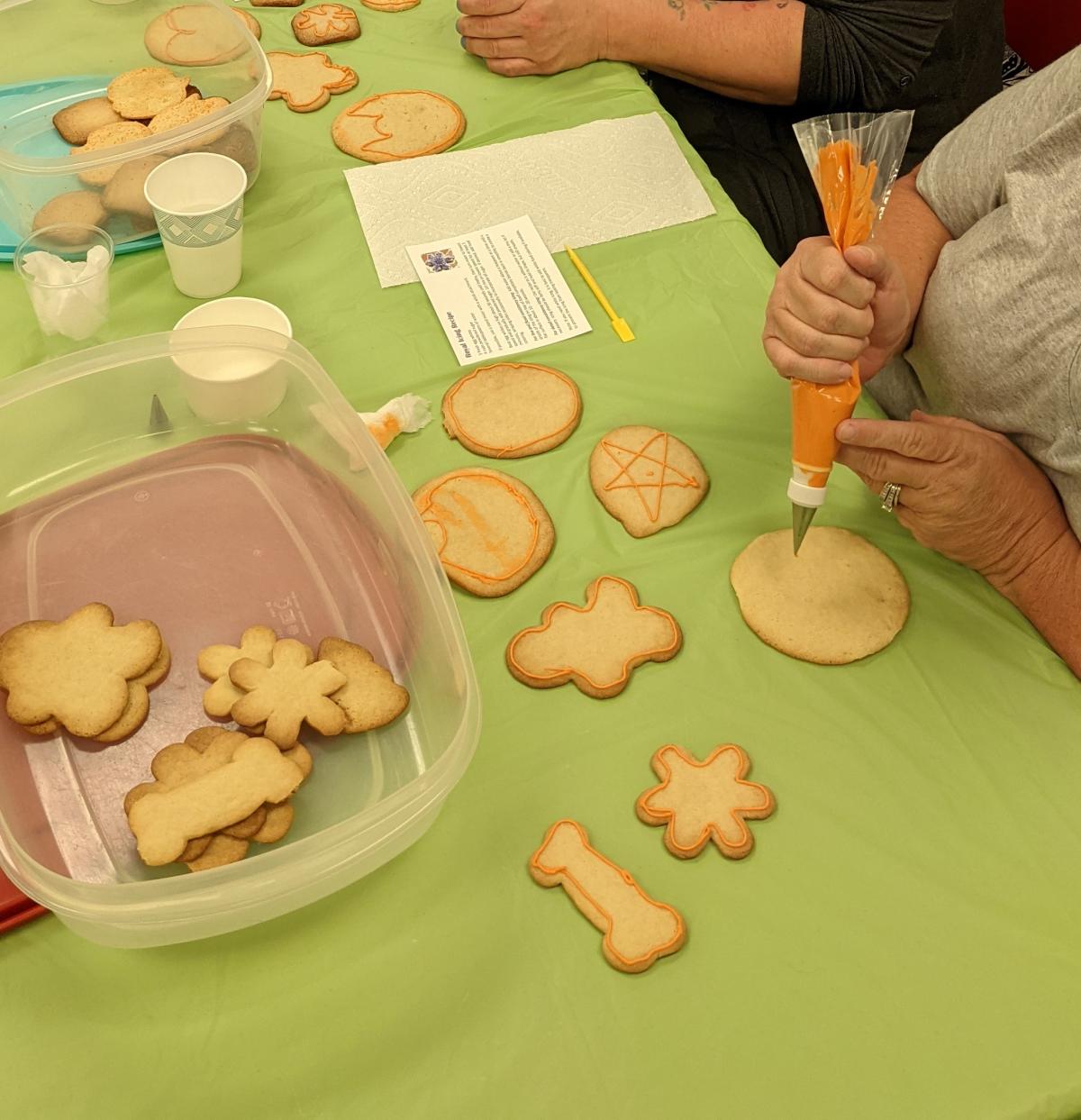 plain cookies being decorated with icing