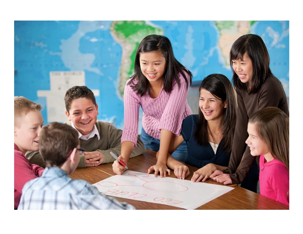 Tweens gathered around a project on a table.