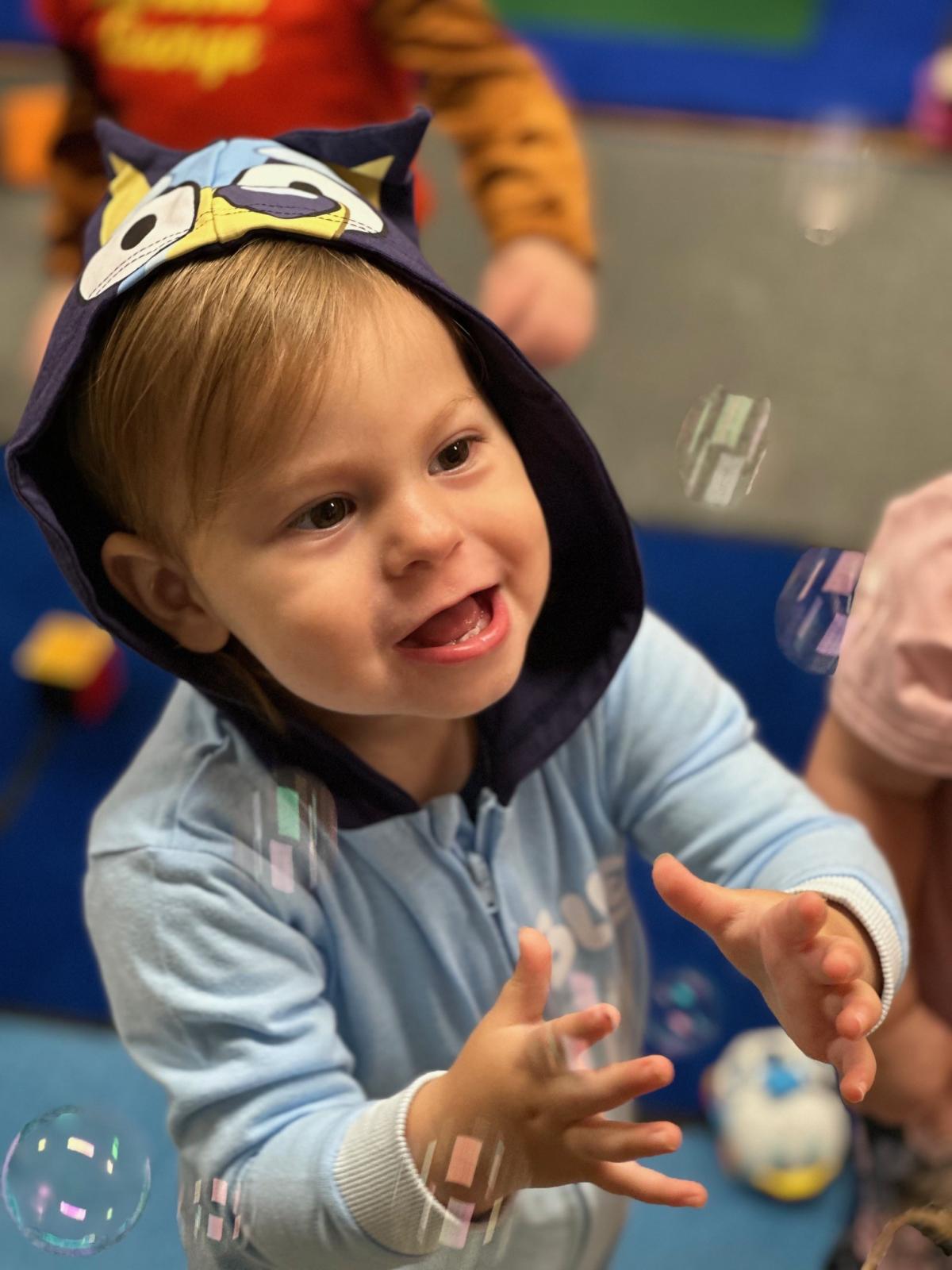 Photo of child catching bubbles during story time.