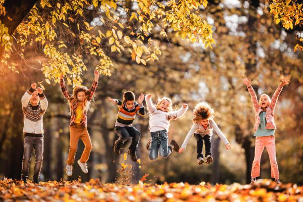 Kids jumping with leaves.