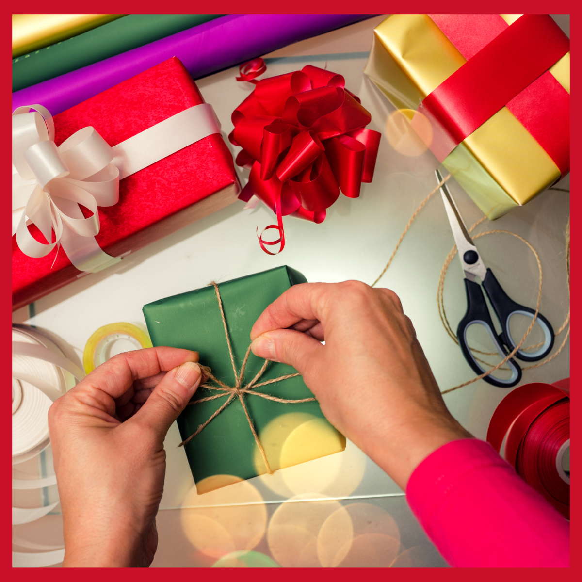 hands tying a bow on a wrapped gift