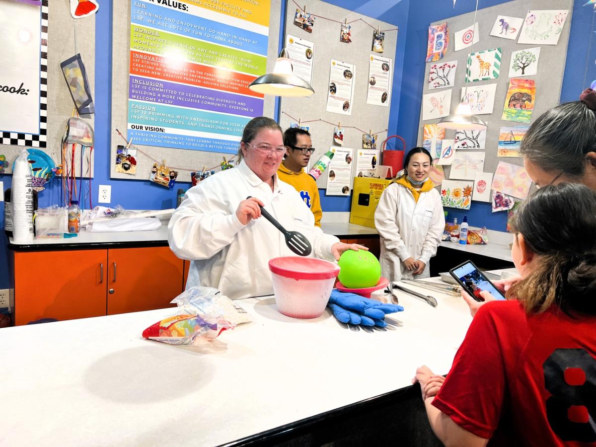 Photo of woman in white lab coat doing science experiment