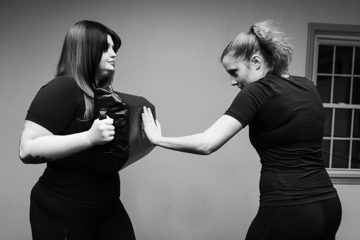 Black and White photo, two women learning in self defense class