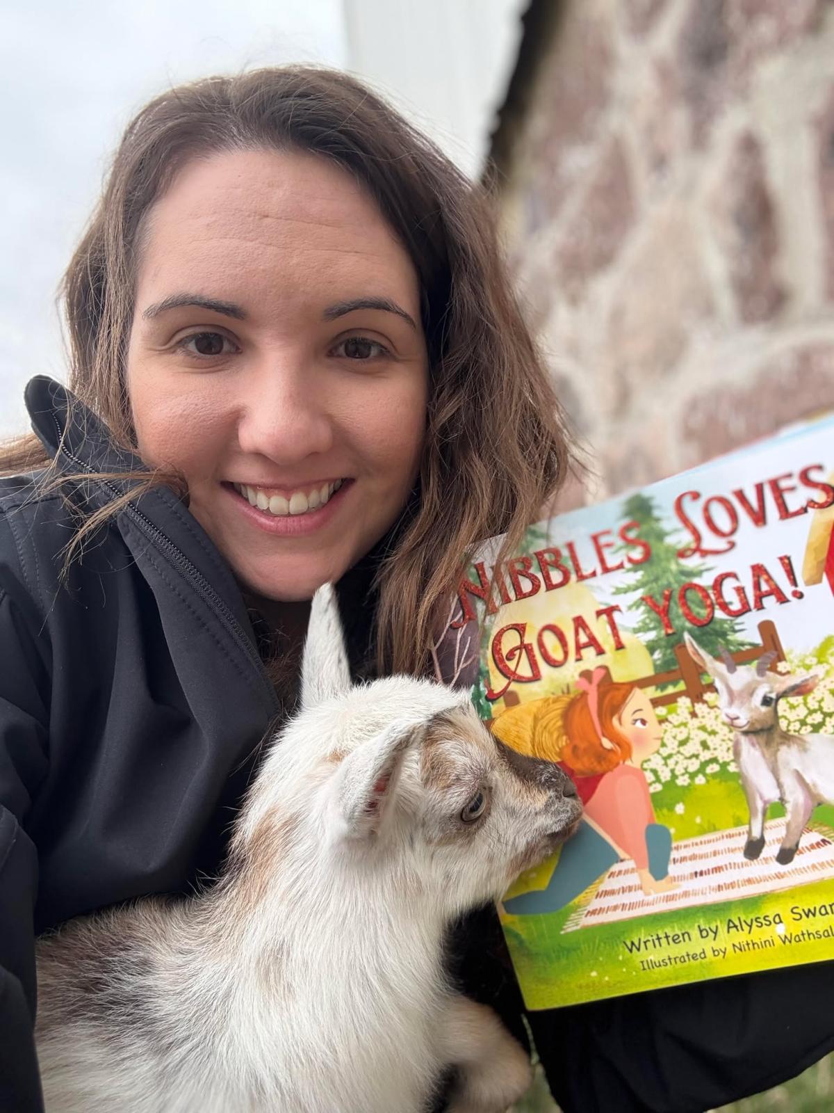 Author Alyssa Swartz with a baby goat and a picture book