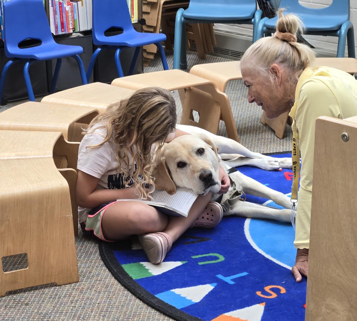 Child reading to KPET dog.