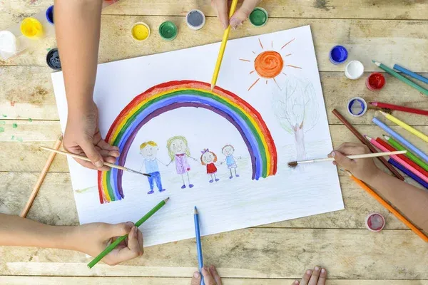 Children drawing a rainbow and family.