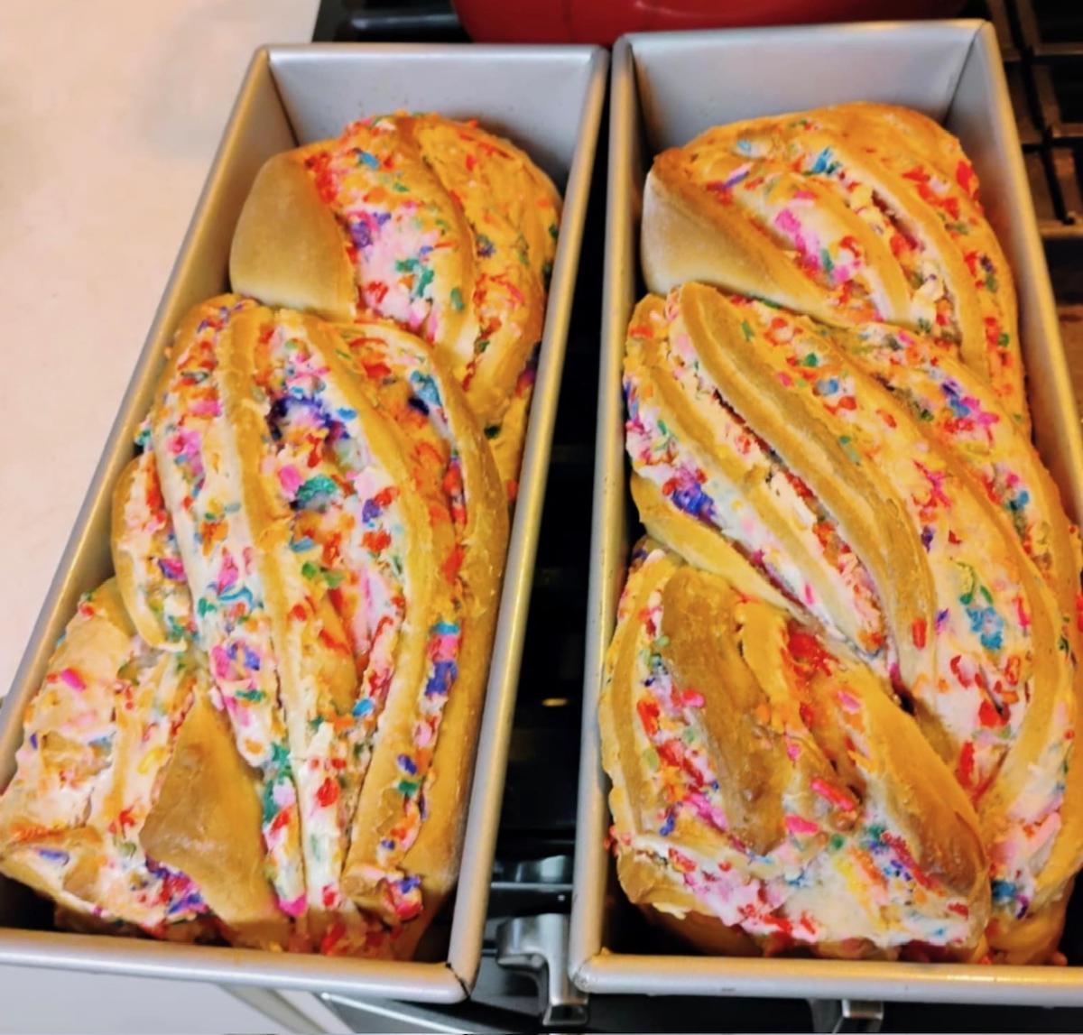Photo of two loaves of babka bread in pans with rainbow sprinkles
