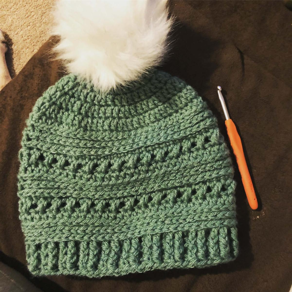 Green hat with white pom pom