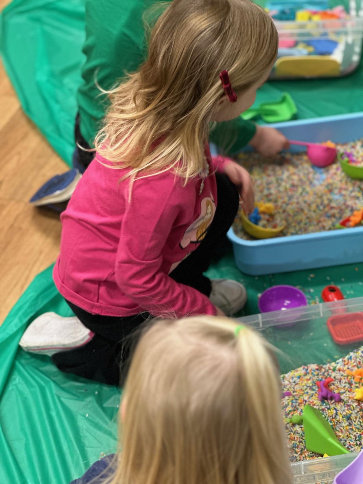 Children playing in sensory bins